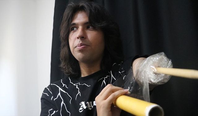 Depremde kolunun büyük bölümünü kaybeden genç, streç filmle sabitlediği bagetle bateri çalıyor